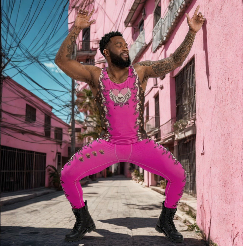 Person wearing a bright pink outfit with skulls, heart, fire, black accents in an urban Mexican setting with pink buildings.