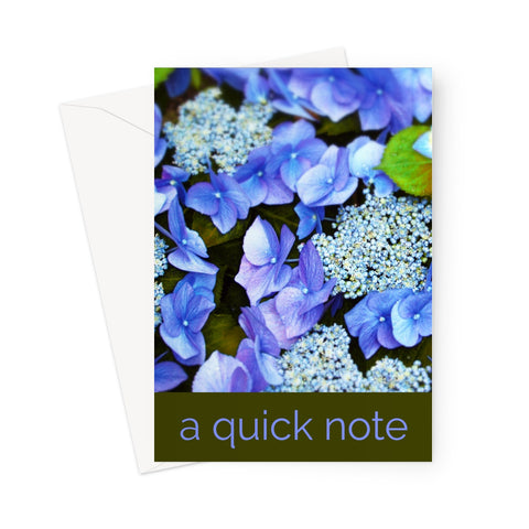 Closeup of blue hydrangeas in a photo greeting card or notecard. A darker strip at the bottom of the card denotes the words "a quick note" 