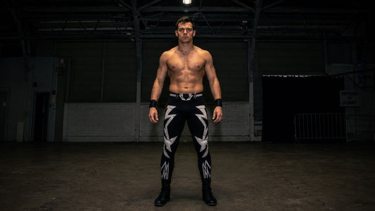 man in bold full-length pro wrestling tights, raw confrontational energy, industrial venue