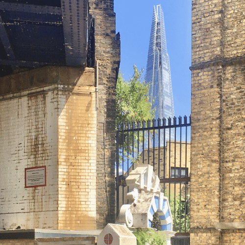 View of the Shard between an old church and railway bridge in Southwark