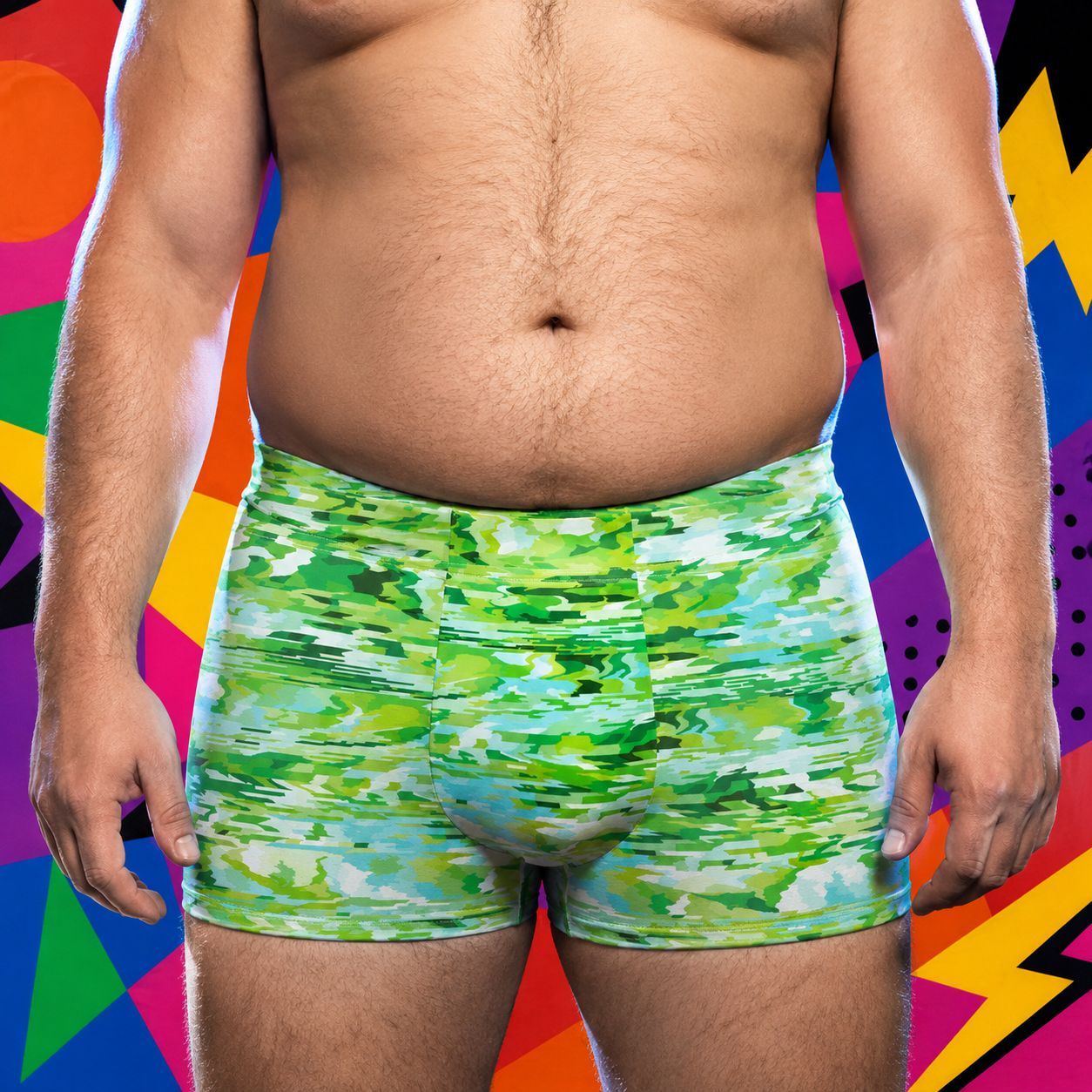 Person wearing green camouflage boxer briefs against a colorful abstract background