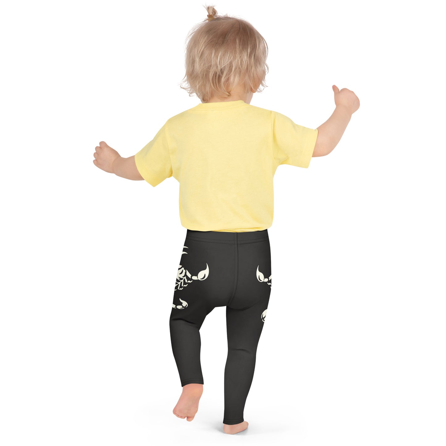 Toddler wearing dark leggings with large printed scorpion on each side, laid flat