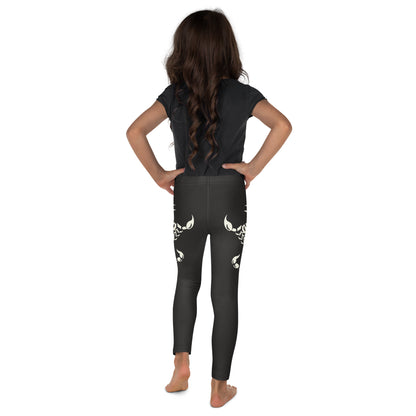 Young girl wearing dark leggings with large printed scorpion on each side - rear view