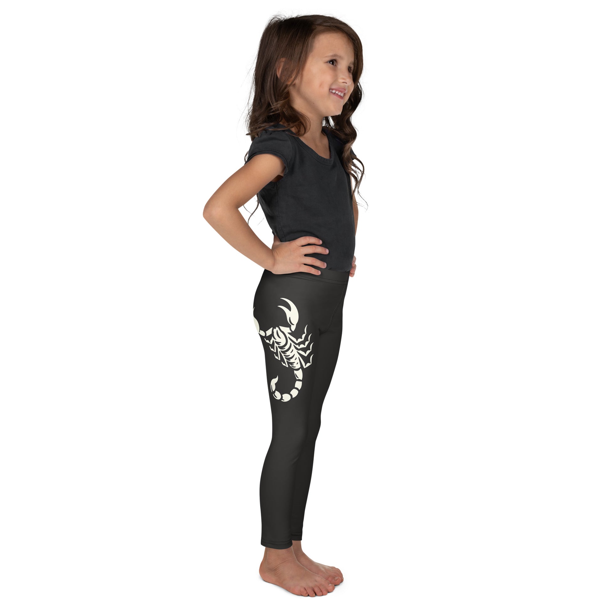 young girl wearing dark leggings with large printed scorpion on each side, laid flat