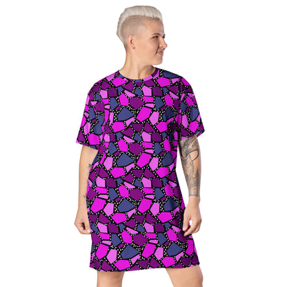  geometric patterned t-shirt dress in a vibrant futuristic Synthwave colour palette against a black and white dotted background. Available here in a metallic purple style.