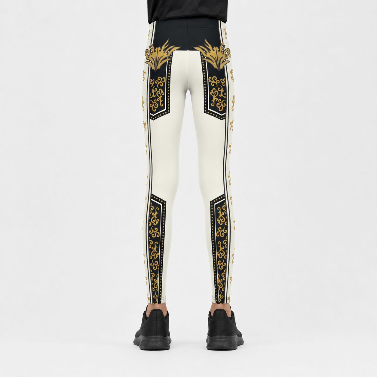 White leggings with black and gold ornate patterns down the sides and thighs, shown from the back on a model wearing black sneakers against a light gray background.