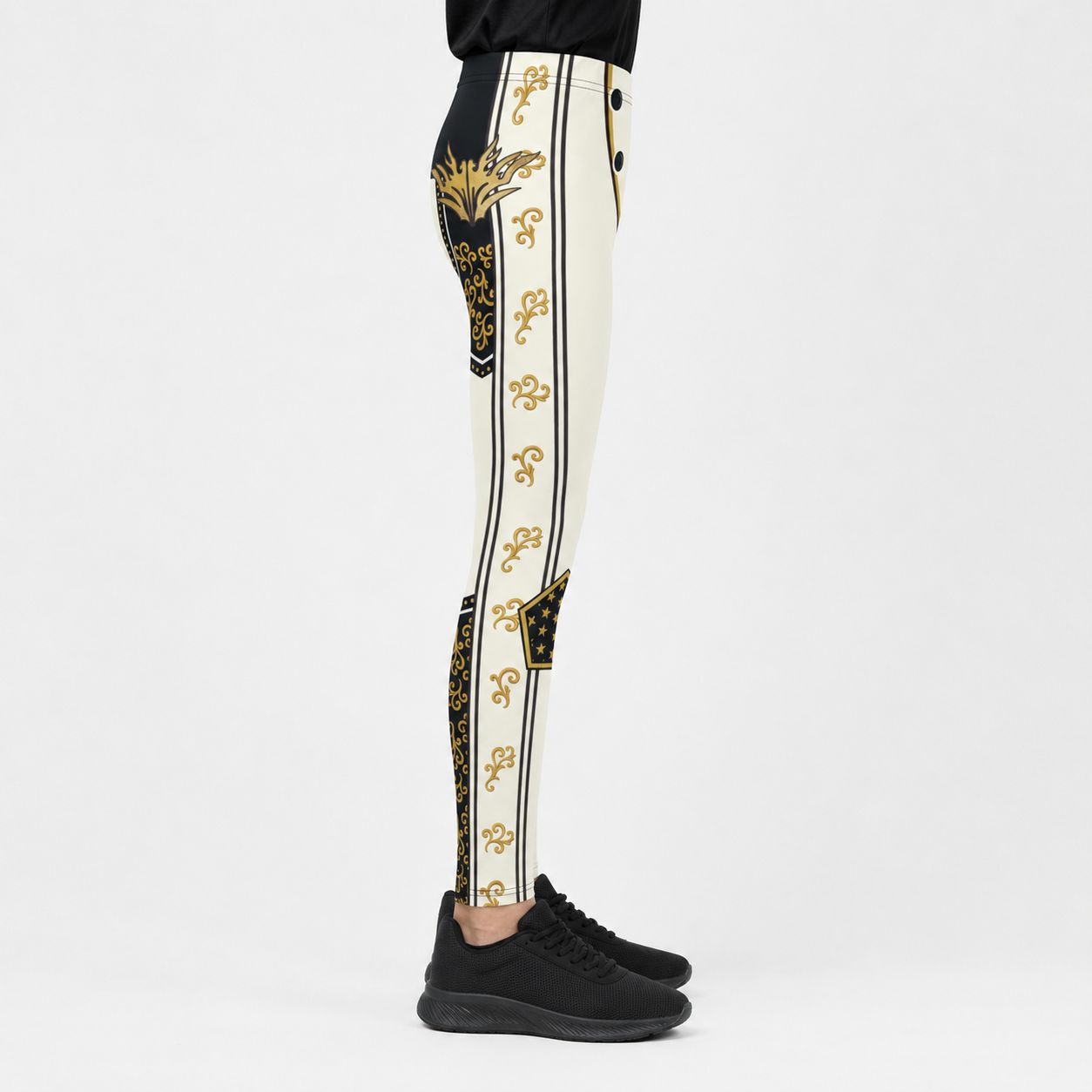 A side-profile view of a youth wearing high-waisted, black athletic leggings with a prominent gold and black ornate pattern down the center and sides, paired with black sneakers against a plain white studio background.
