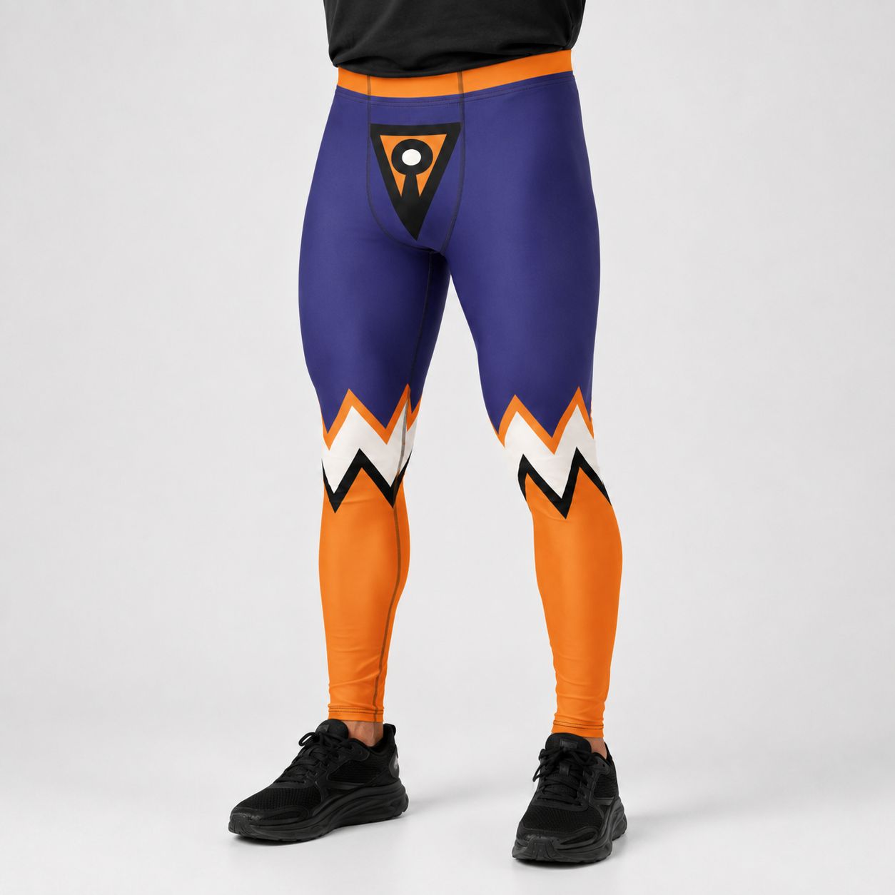 A person wearing tight-fitting athletic leggings in purple and orange with white and black zigzag accents near the knees, shown from the waist down on a light gray studio background.
