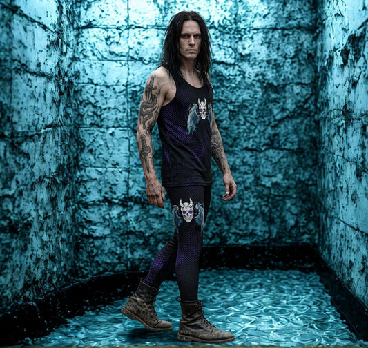 Man with tattoos standing in a blue-lit room with textured walls wearing skull and wings leggings