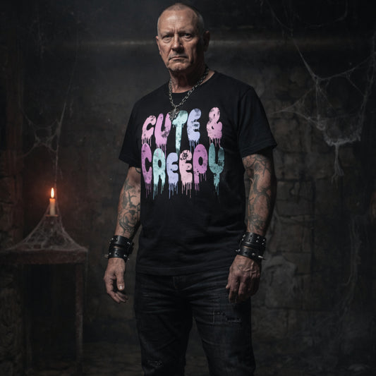 Man wearing a black t-shirt with fun pastel goth cute and creepy text in a dark, eerie setting