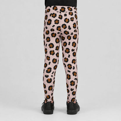 Pink leopard print leggings shown from the back on a child model, featuring a black and brown spotted pattern on a light pink base, paired with black shoes against a light gray background.