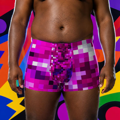 Person wearing colorful pixelated purple boxer briefs against a multicolored abstract background