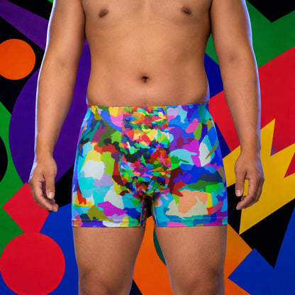 Person wearing rainbow coloured boxer briefs against a multicolored abstract background