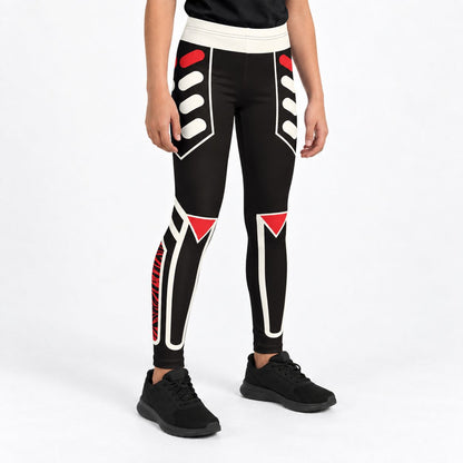 A model from the waist down wearing black wrestling cosplay leggings with white and red geometric patterns, paired with black sneakers, against a plain white studio background.