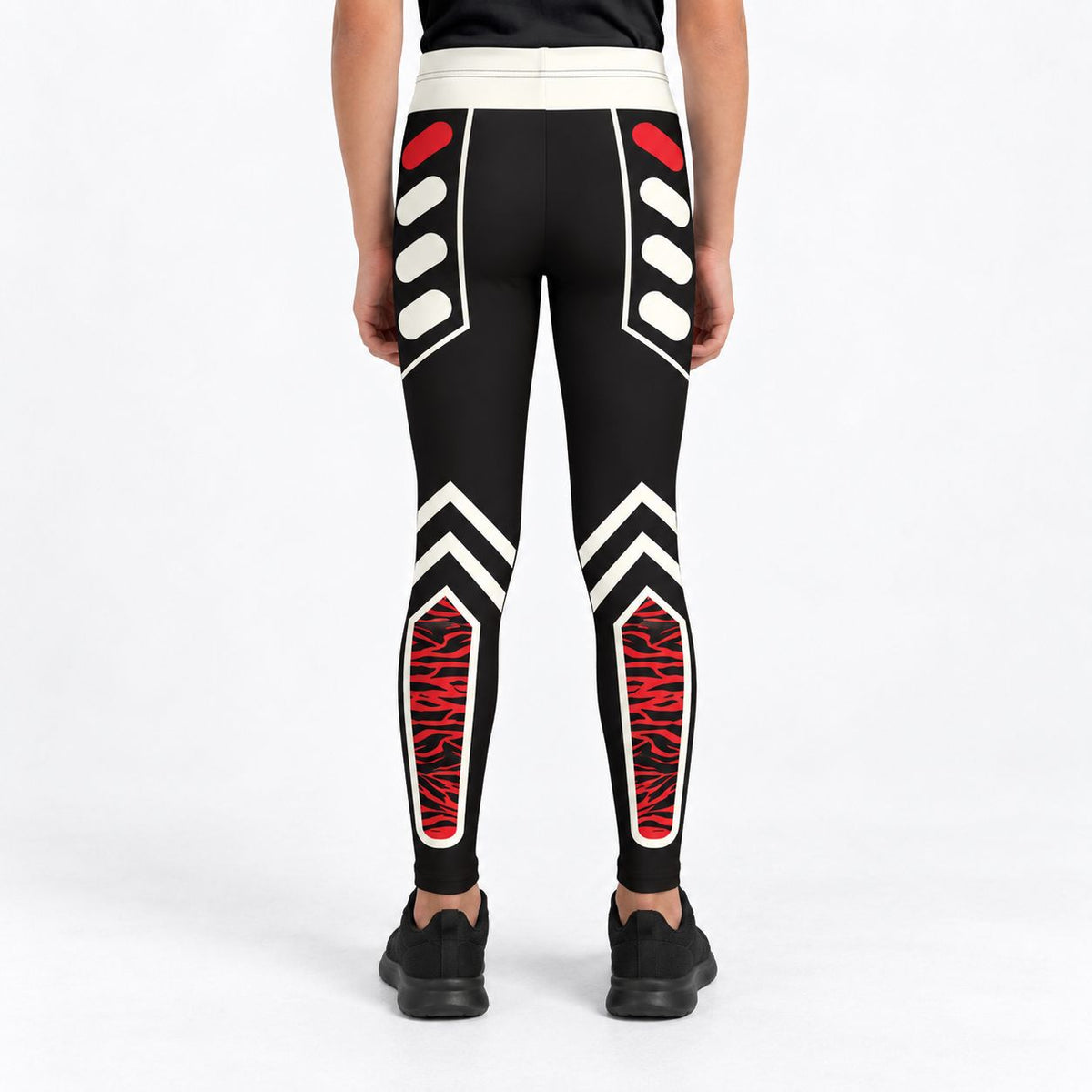 Rear view of a model wearing black leggings with white and red geometric tribal-style patterns, paired with black sneakers, against a plain white studio background.