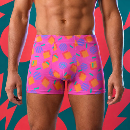 Person wearing colorful geometric-patterned pink underwear against a vibrant abstract background