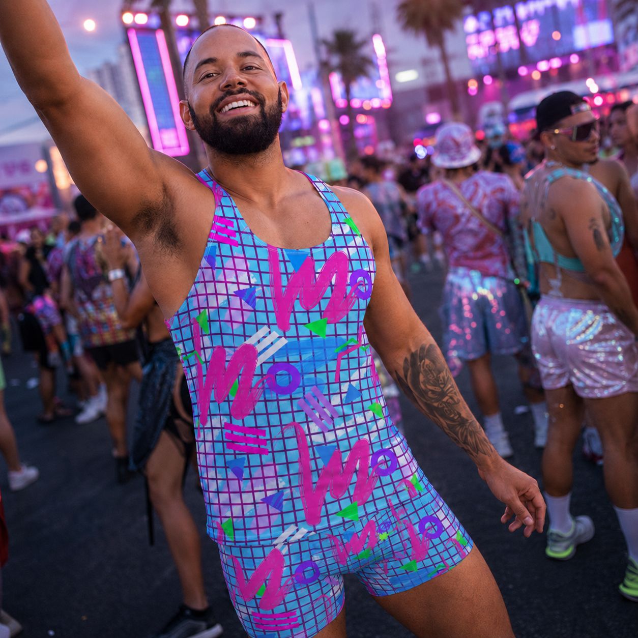 Man in a colorful outfit with text at a party or event with neon lights and people in the background.