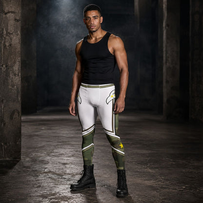 A muscular man stands in a dark, industrial warehouse setting wearing white and olive green athletic compression leggings with a black tank top and black boots.