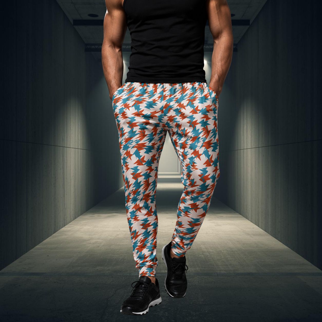 Person wearing colorful patterned jogging pants in a dark hallway