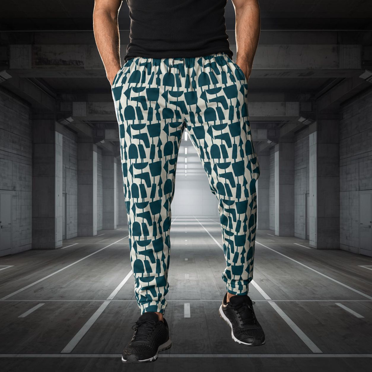 Person wearing patterned jogging pants in a concrete hallway