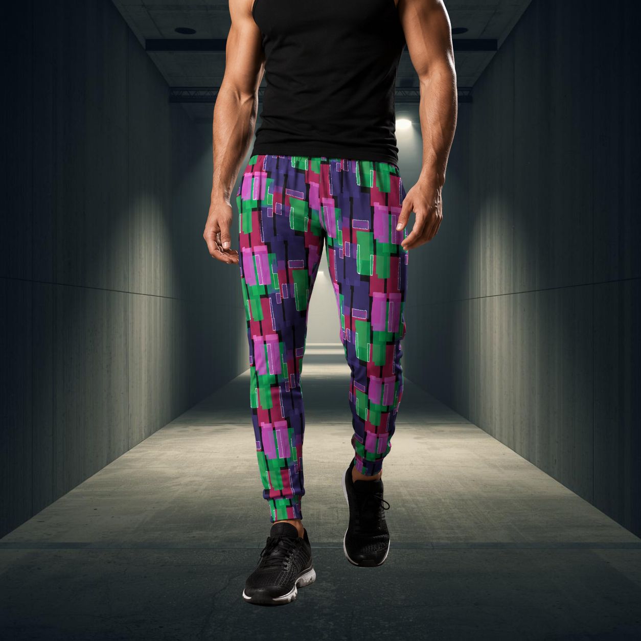 Person wearing colorful checkered jogging pants walking down a dark hallway.