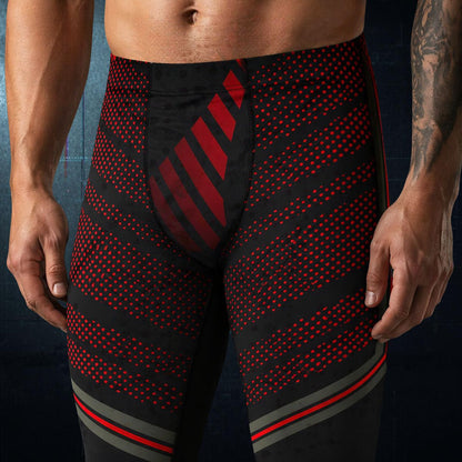 Black and red patterned leggings worn by a person on a dark background - front view