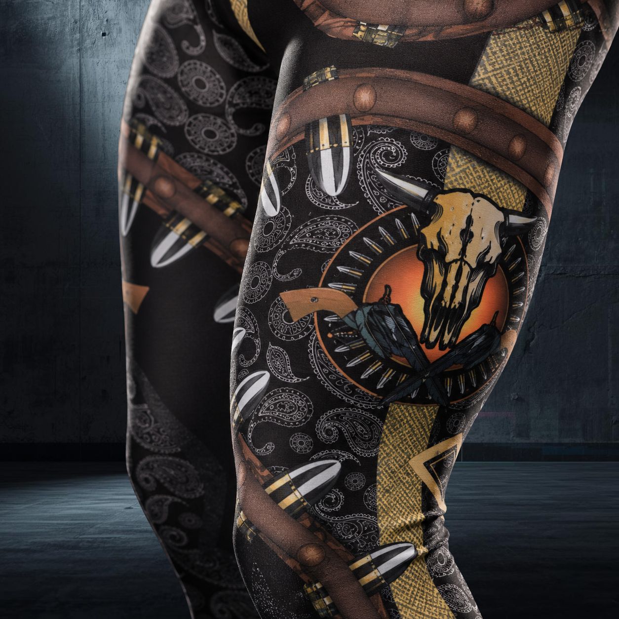 closeup of men's leggings with bullets and guns design, including paisley and gold print and cow skull motif