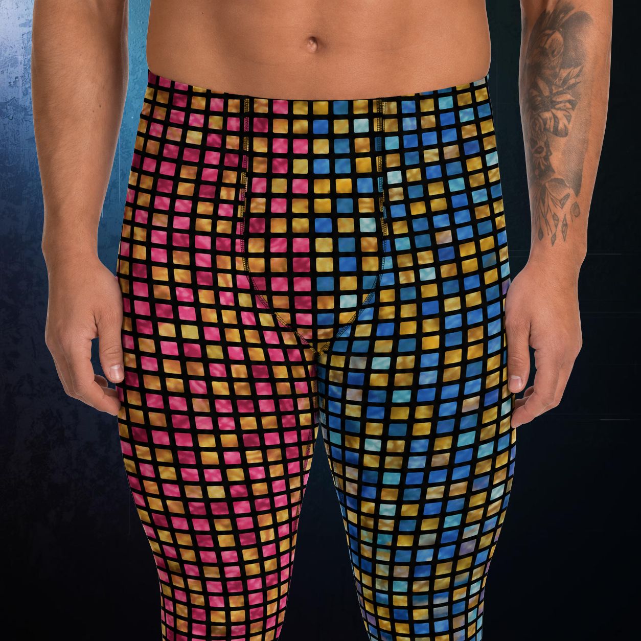 Multicolored checkered wrestling pants worn by a person on a dark background