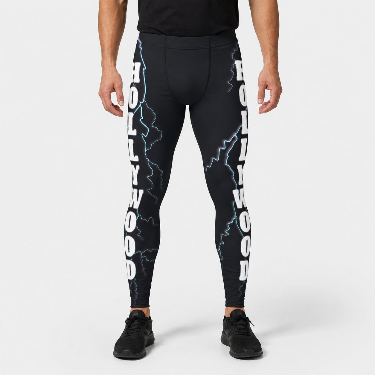 Person wearing black leggings with 'Hollywood' text and lightning designs on a white background