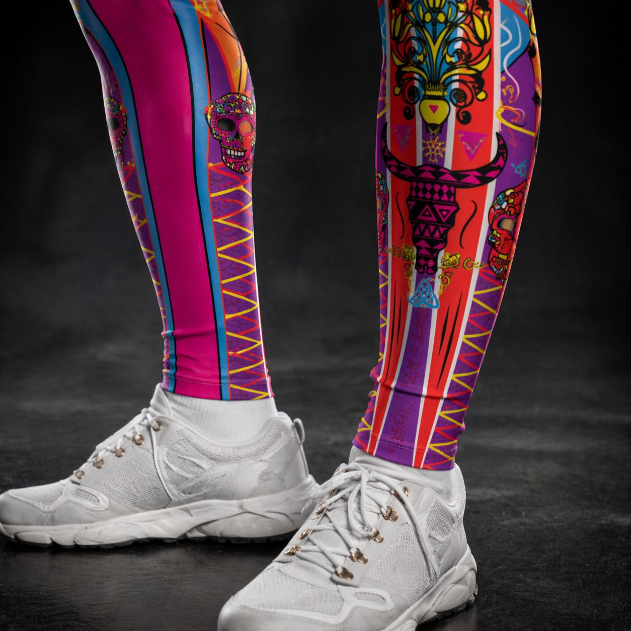 bold lucha libre leggings in closeup at bottom of legs with matador bullls, skulls and other luchador symbols with white sneakers on a dark background