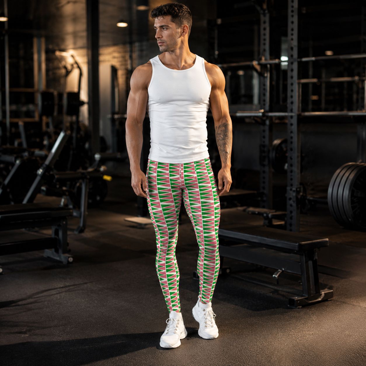Man in gym wearing green and salmon geometric leggings with a white tank top
