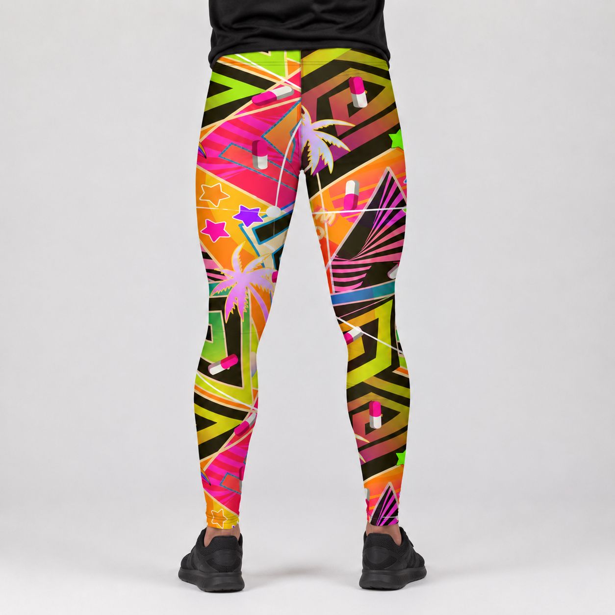 A person shown from the waist down wearing colorful geometric print leggings with palm trees, stars, and lipstick motifs, paired with black sneakers against a light gray studio background.