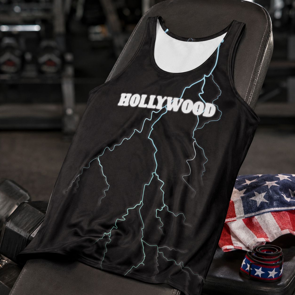 Black tank top in closeup with blue lightning bolt and 'HOLLYWOOD' print on a gym bench