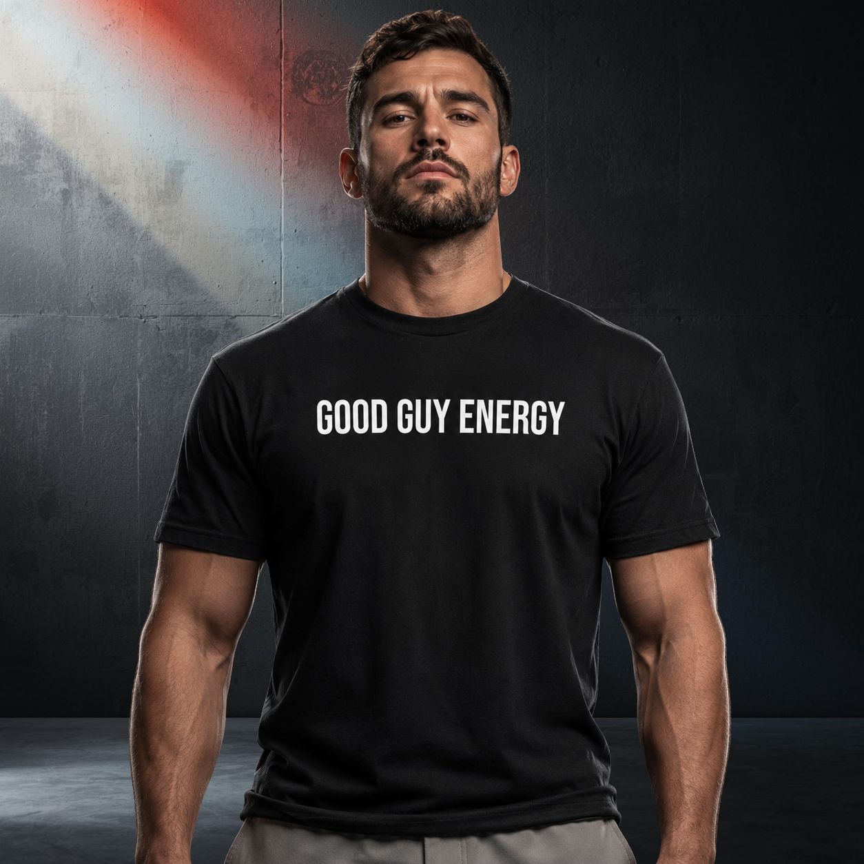 Man wearing a black wrestling babyface t-shirt with 'GOOD GUY ENERGY' text against a dark background