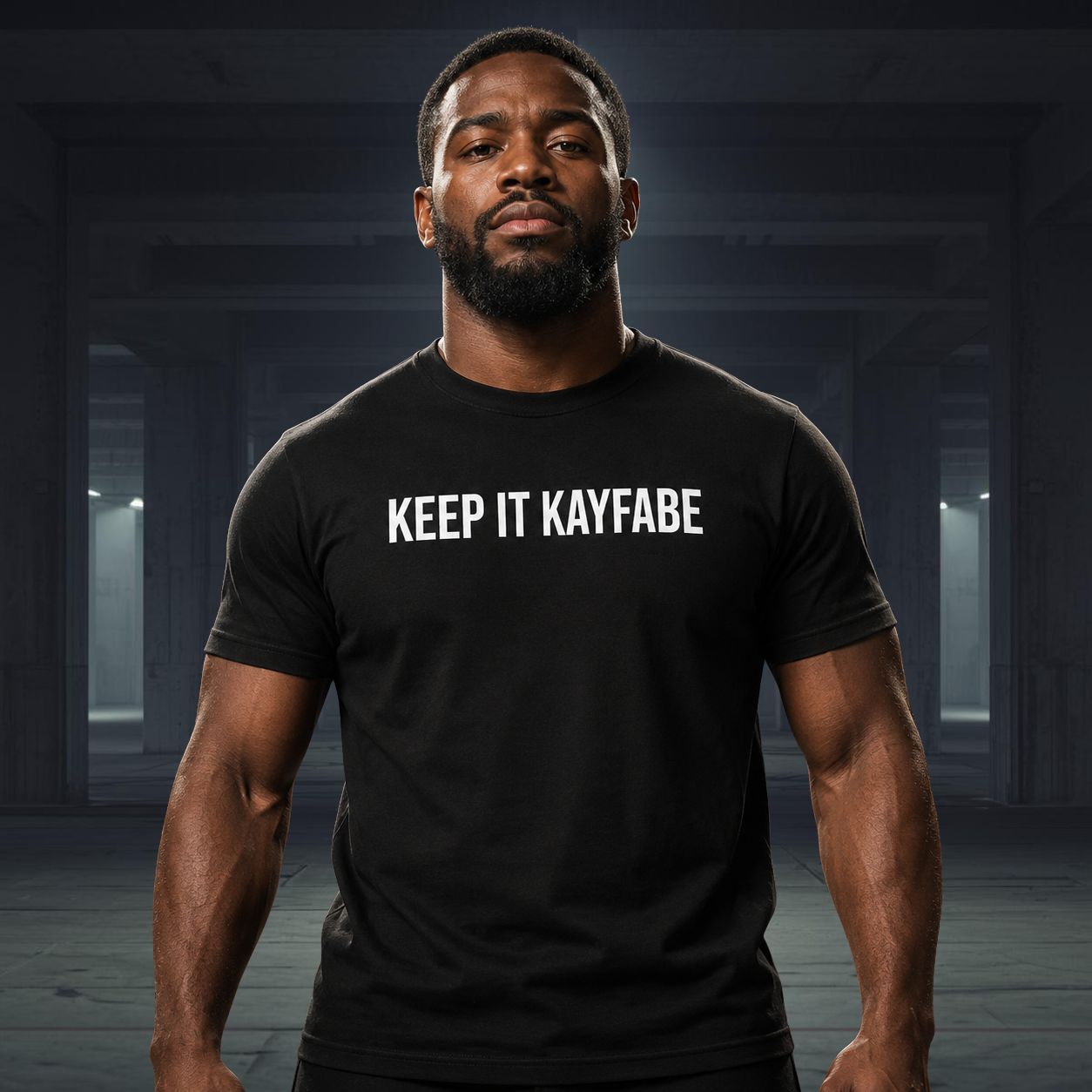 Man wearing a black t-shirt with 'KEEP IT KAYFABE' text in a dark indoor setting