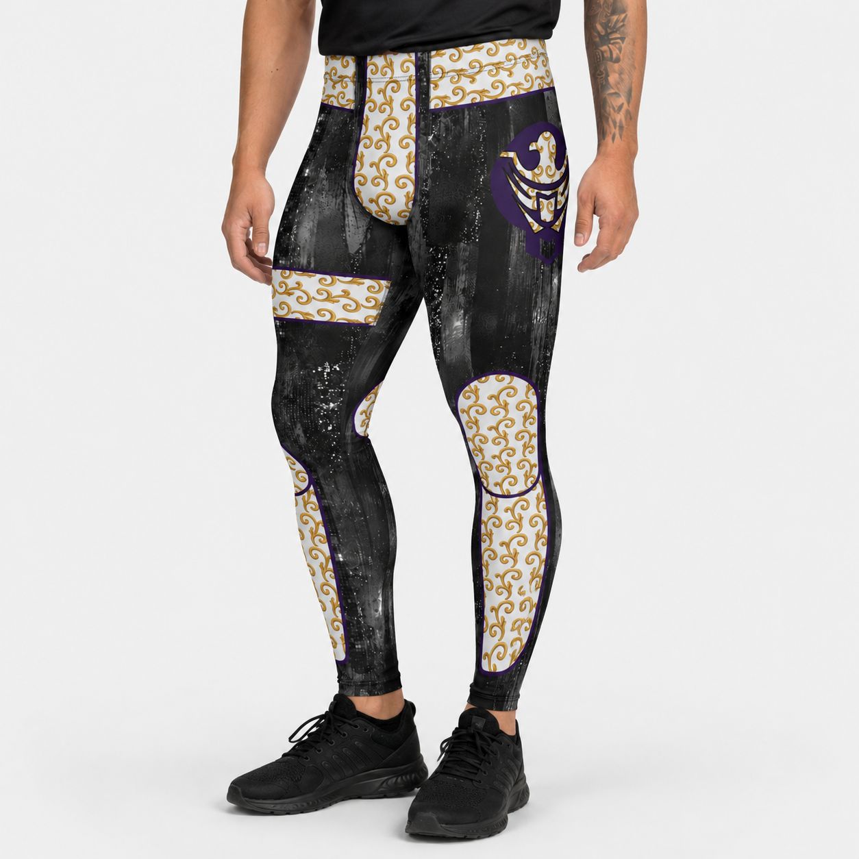 Person wearing black leggings with gold and purple designs on a white background
