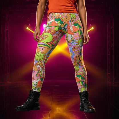 woman wearing colorful orange leggings with a psychedelic theme, mushrooms, suns, butterflies and flowers.