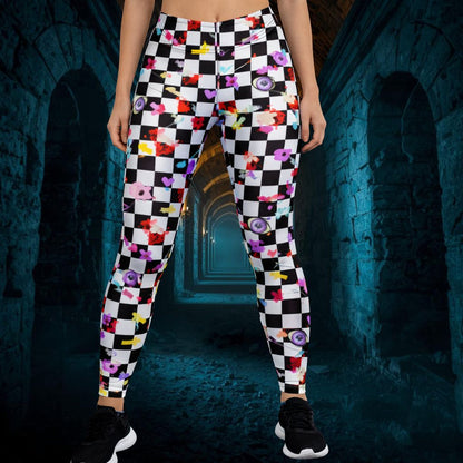 Person wearing colorful checkered pants with a pattern of eyes in a dark, tunnel-like setting.