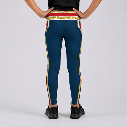 A person shown from the back wearing teal leggings with a gold and red ornate patterned waistband and side stripes, paired with black sneakers on a light gray studio background.