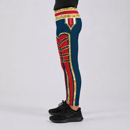 A person wearing navy blue leggings with bold red and gold military-style stripe patterns, paired with black sneakers, shown against a light gray studio background. Side view.