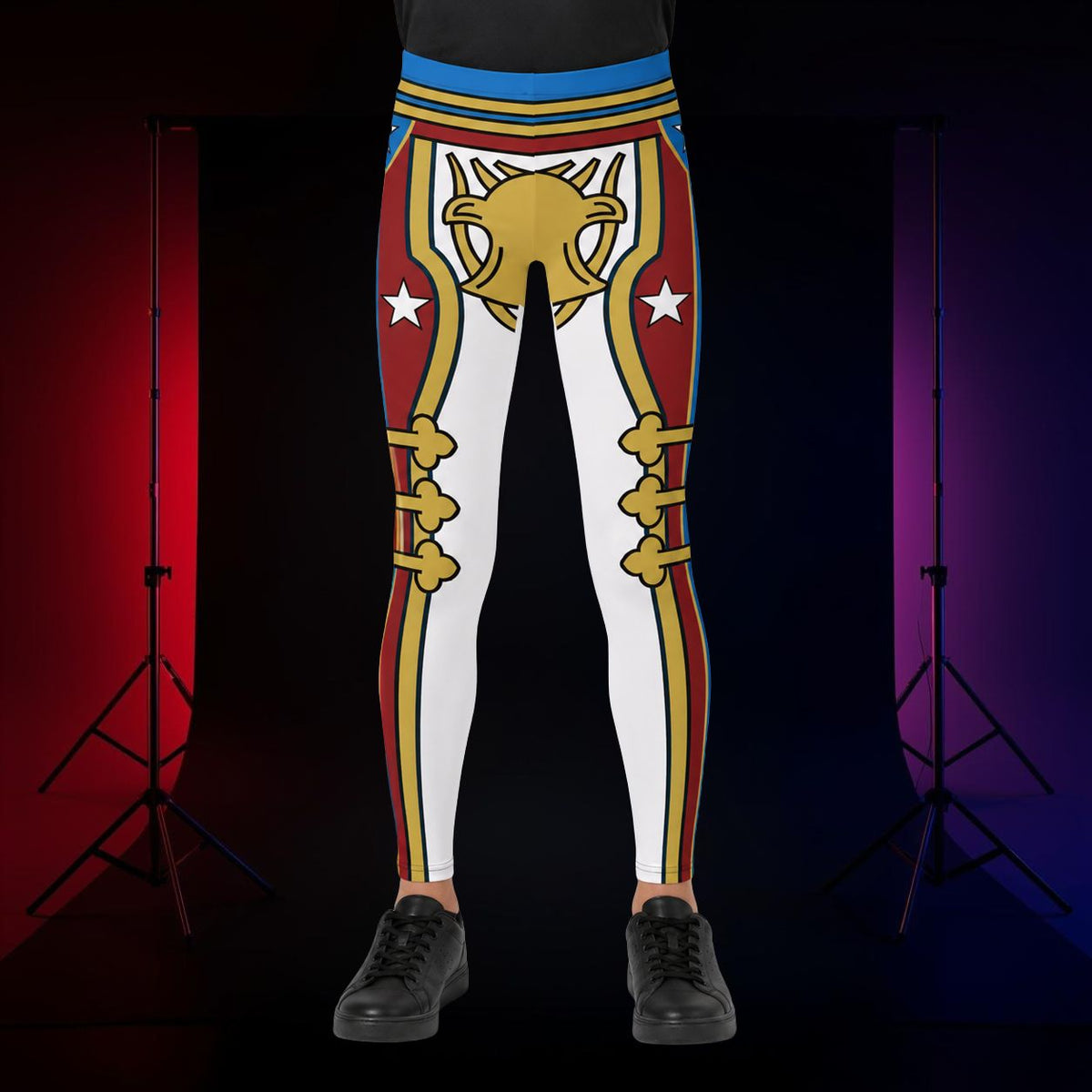 A person wearing cosplay wrestling tights in youth size with a bold retro military-style graphic featuring a large gold emblem, red and blue sections, and white star details, standing against a dark studio backdrop with red and purple lighting and visible stand legs.