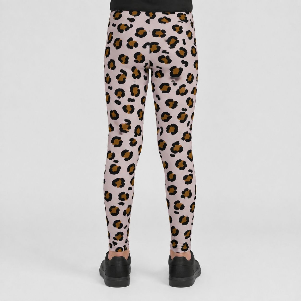 A person shown from the back wearing leopard-print leggings with black shoes, photographed against a clean light gray studio background.