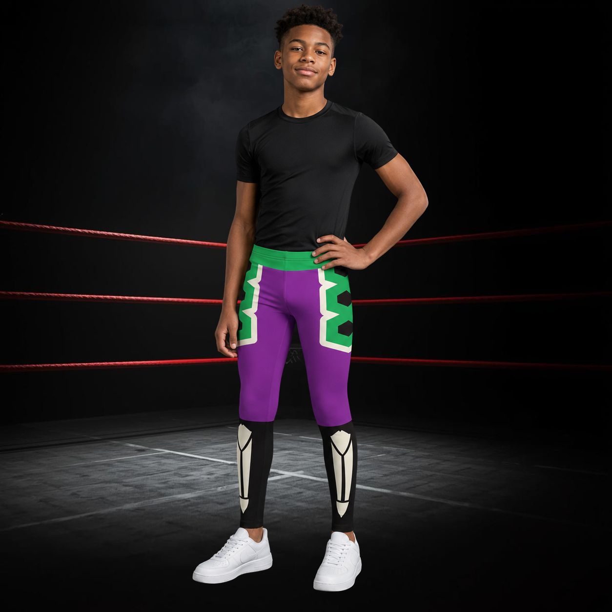 Person wearing a black t-shirt and purple wrestling lucha libre wrestling tights with green accents in a ring.