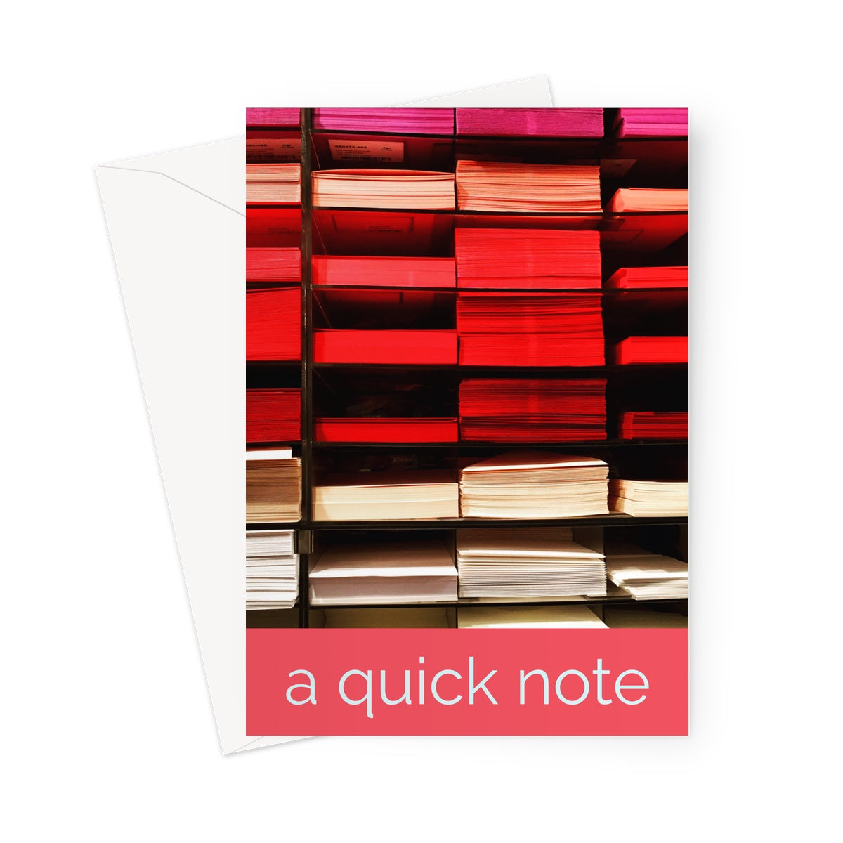 A shelf of coloured sheets of paper ranging from pink, red to yellow and white in a photo greeting card or notecard. A salmon coloured strip at the bottom of the card denotes the words "a quick note" | Billington Pix Greeting Cards