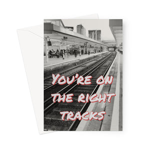 This greeting card shows the words "You're on the right tracks" in white letters with red shadowing, overlaying the perspective view in black and white of railway lines at a railway station