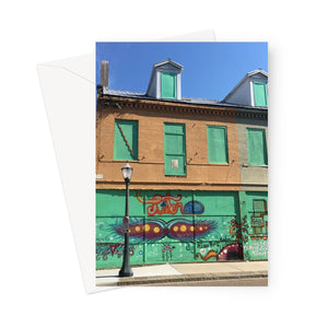 This greeting card shows a nineteenth century building with green boarding, providing a colourful pallete for some creative graffiti