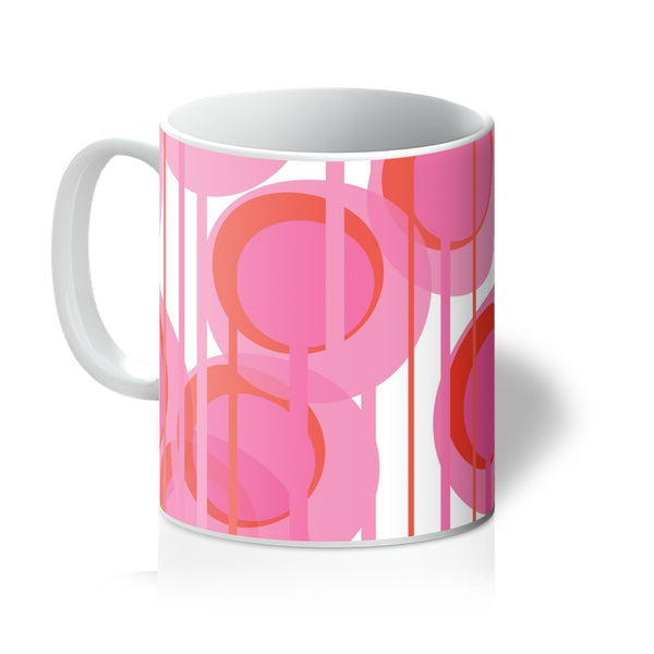 This Mid-Century Modern style coffee or tea mug consists of colorful geometric circular shapes in various tones of pink, connected vertically by narrow tentacles to form and almost hanging mobile type abstract circular pattern on a white background