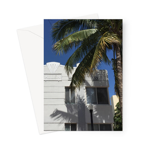 This greeting card shows a geometric detailed white and pale grey coloured house behind a large palm and under a deep blue sky.