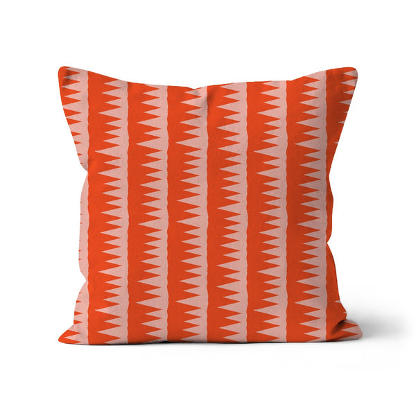 This Mid-Century Modern style couch pillow design consists of colorful pink jagged columns of geometric triangular shapes stacked upon each other like columns against an orange red background