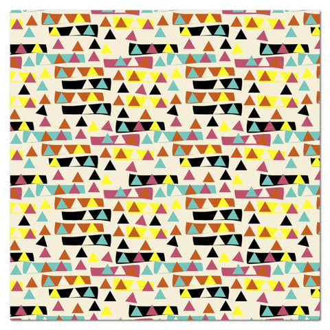 The patterned kitchen table cloth has an abstract triangular pattern with triangles in vintage style tones of yellow, burnt orange, teal and black inside and outside blocks of colour against a cream background.